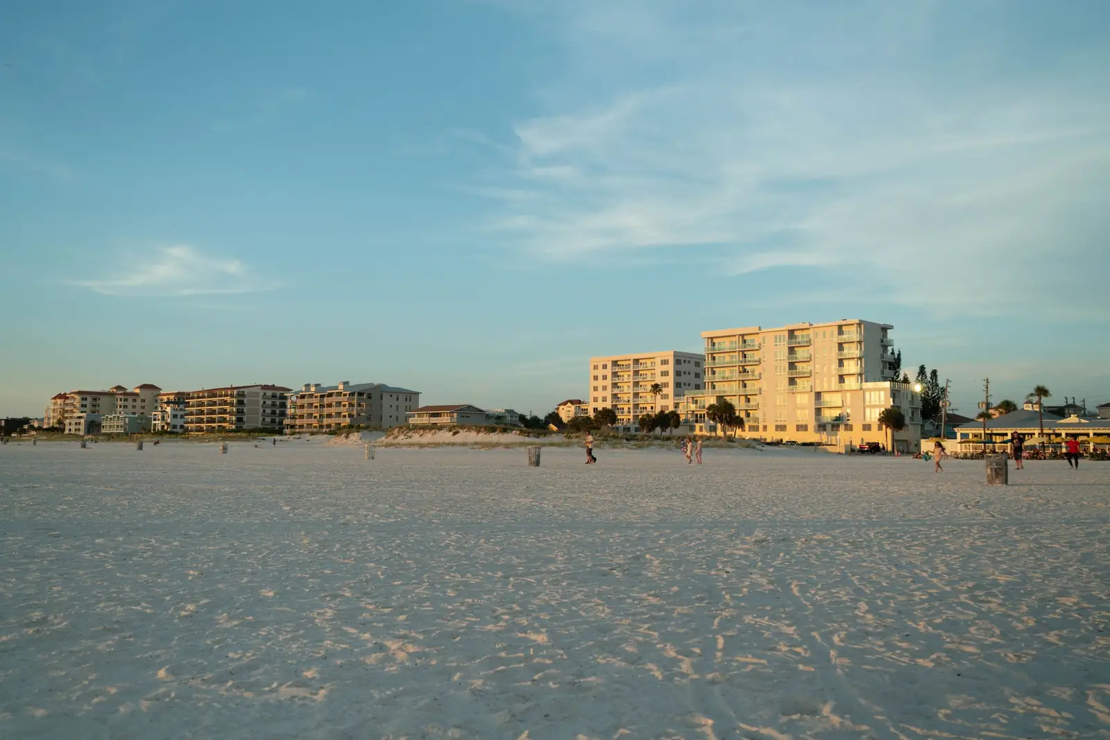 Sunset over a sandy beach and calm water.